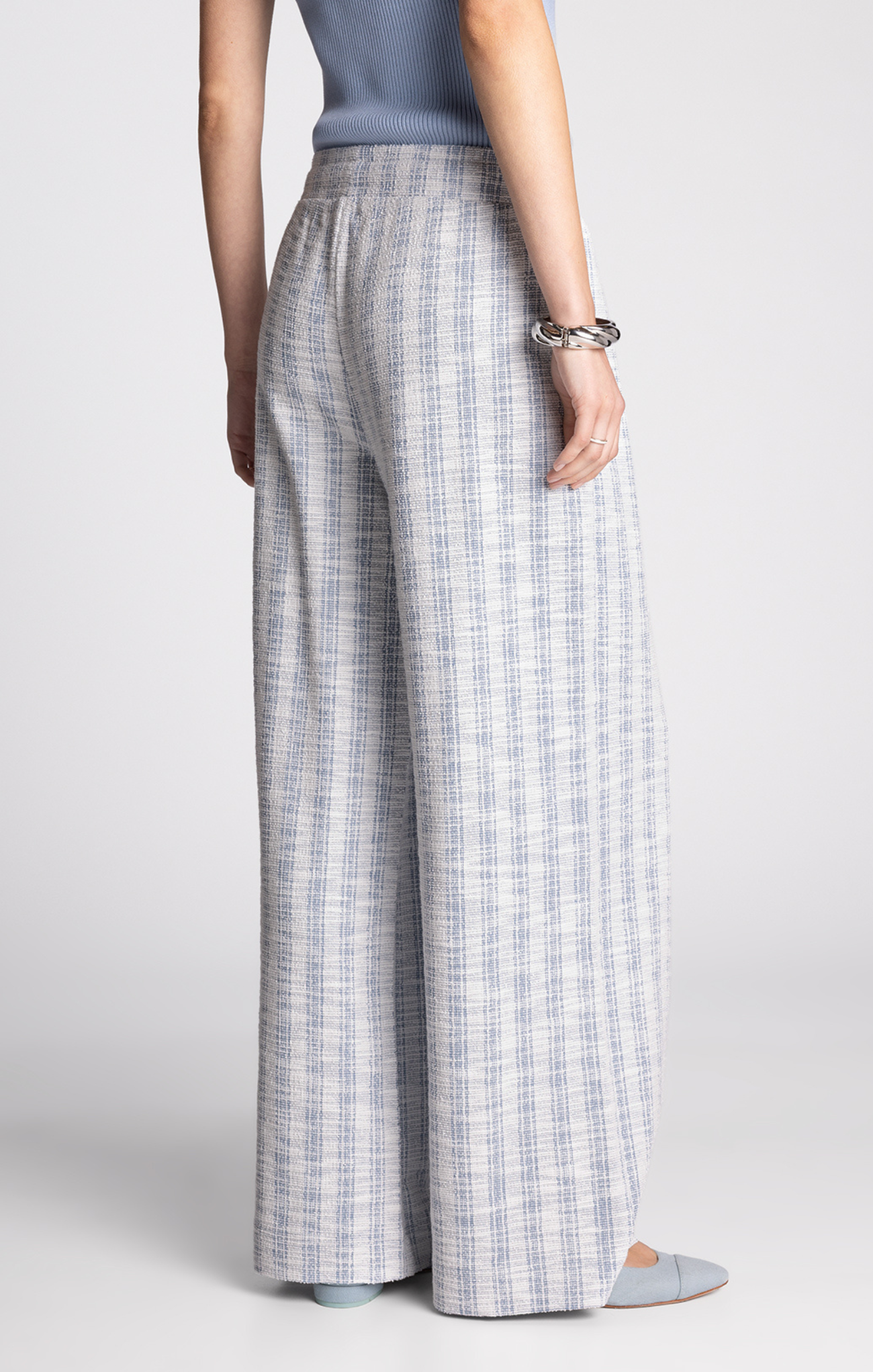 Person wearing plaid wide-leg pants on a plain background