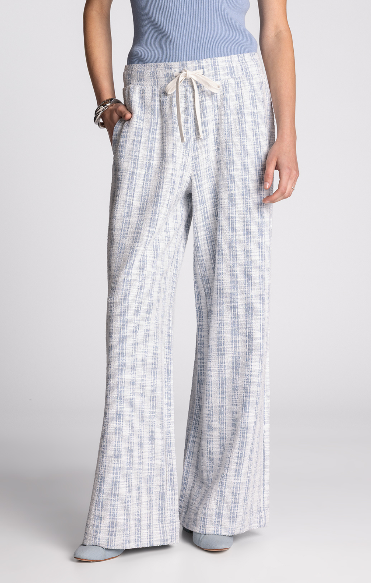 Person wearing plaid pants on a plain background