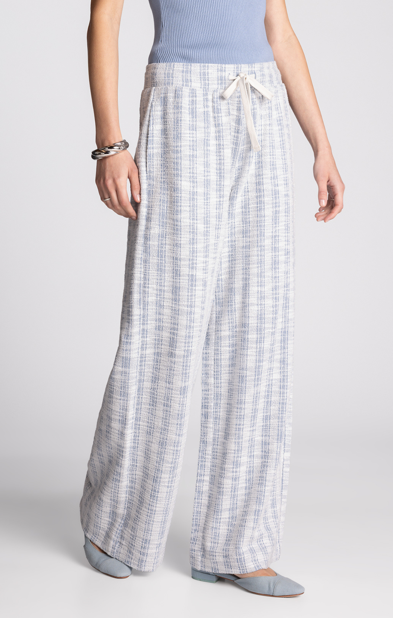 Person wearing plaid pants on a plain background