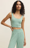 Woman wearing a green athletic outfit against a beige background