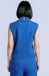 A person shown from the back wearing a sleeveless blue knit mock-neck top and matching blue knit bottoms against a light gray studio background.
