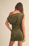 Woman wearing an olive green off-shoulder dress against a beige background
