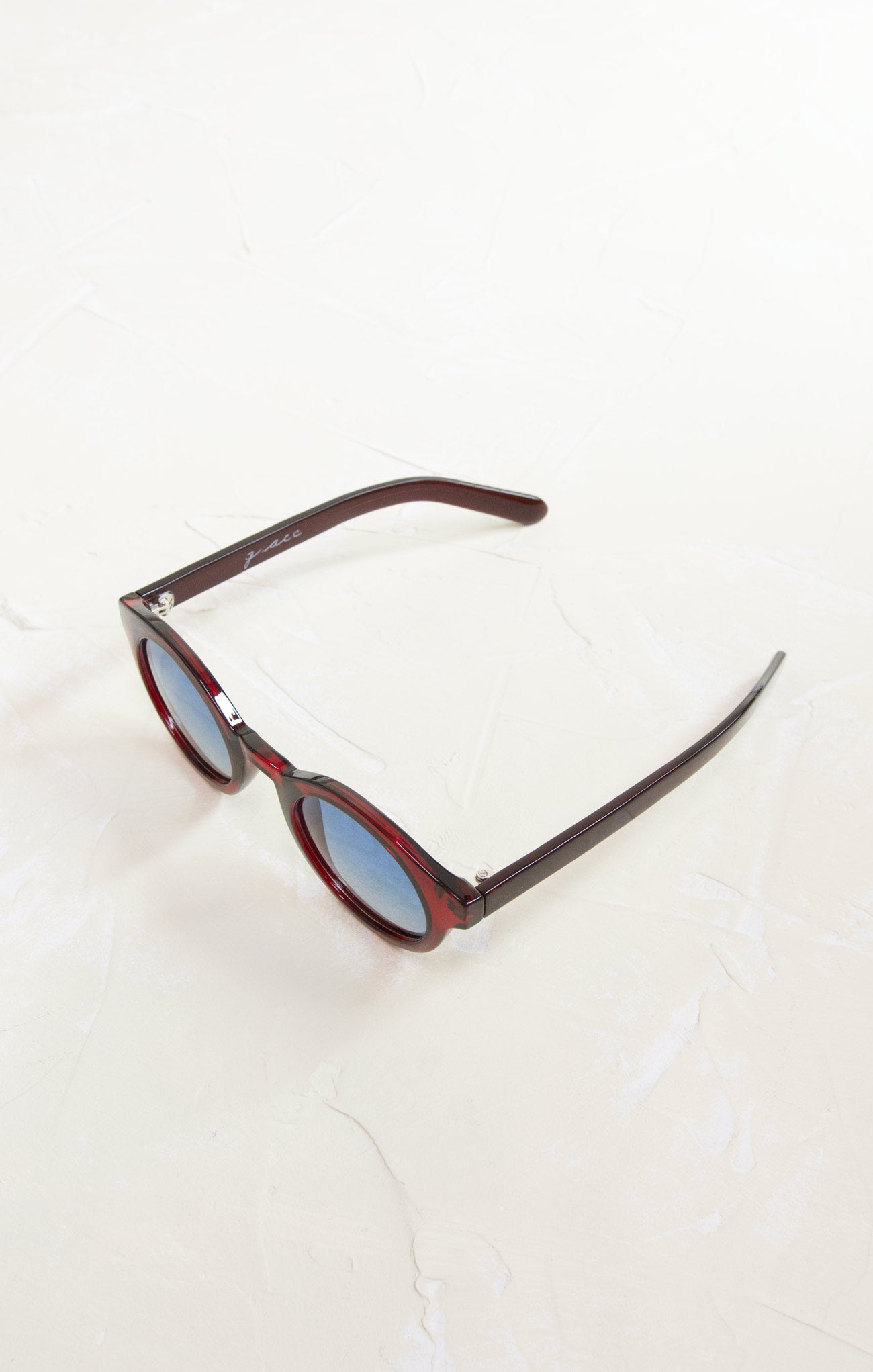 Sunglasses with a brown frame and blue lenses on a white background