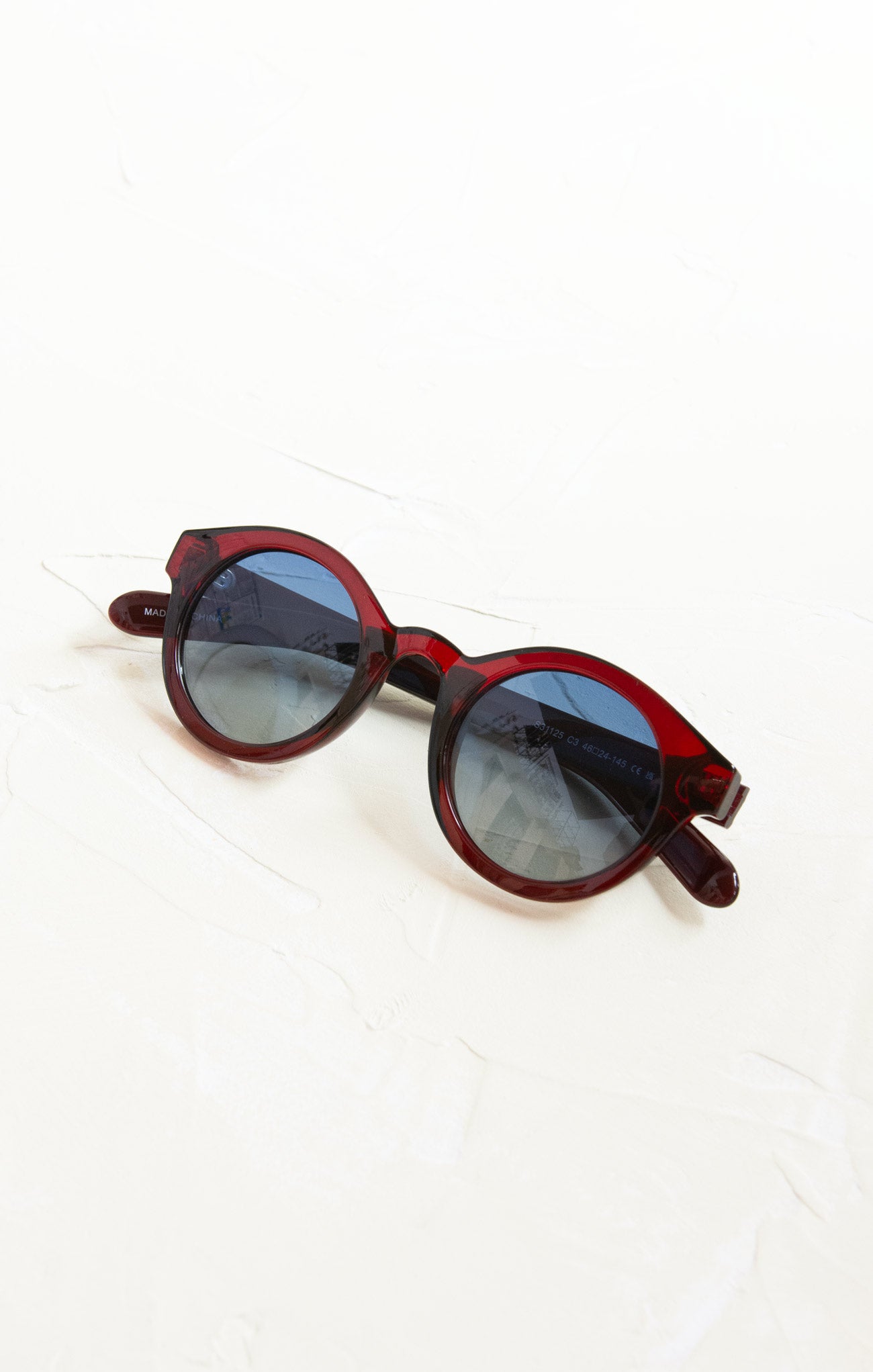 Red sunglasses with dark lenses on a white background
