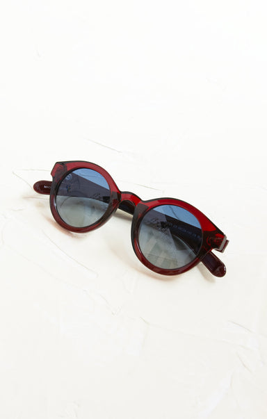 Red sunglasses with dark lenses on a white background