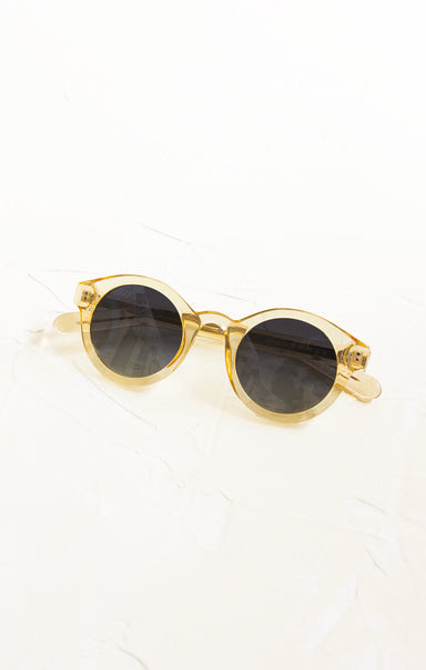 Gold-framed sunglasses with dark lenses on a white background