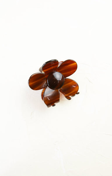 Brown flower-shaped brooch on a white background