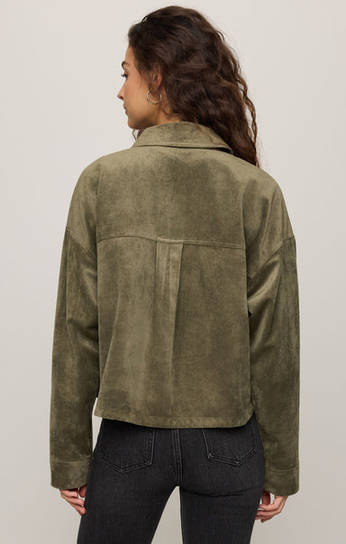 Person wearing an olive green jacket on a plain background