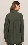 Person wearing a green jacket on a plain background