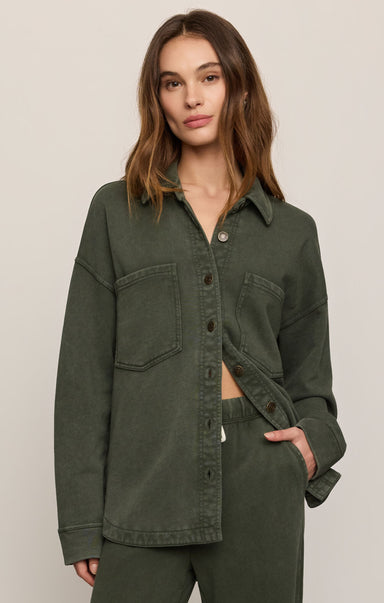 Woman wearing a green jacket on a plain background
