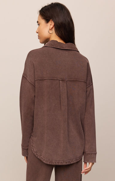 Woman wearing a brown jacket on a beige background