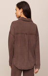 Woman wearing a brown jacket on a beige background