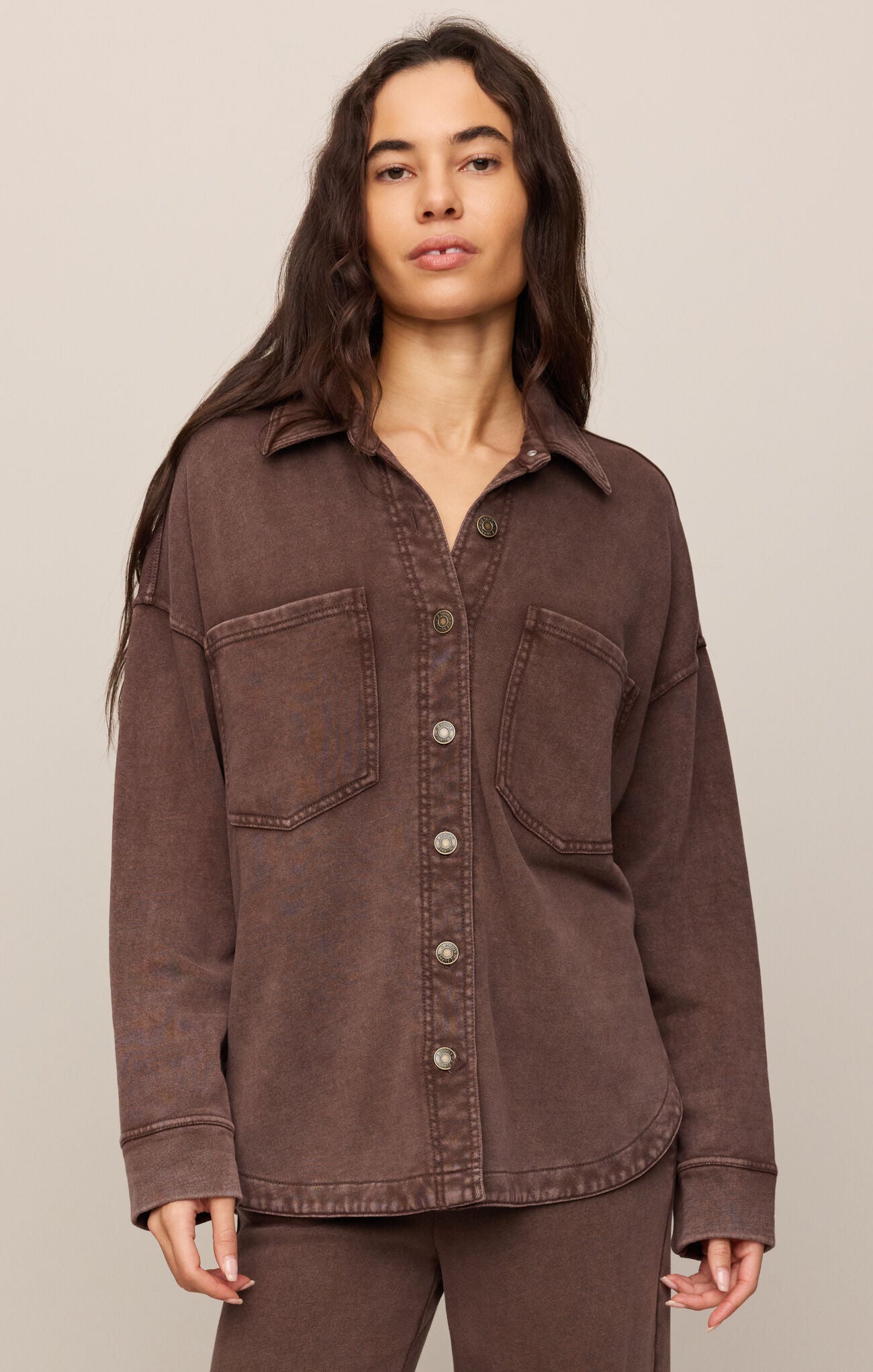 Woman wearing a brown jacket on a beige background