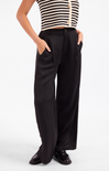A model wearing black wide-leg trousers with side pockets, paired with a black and white striped top and black loafers, shown from the chest down on a white studio background.