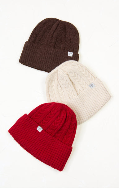 Three knit hats in brown, red, and beige on a white background
