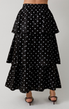 Black tiered skirt with white polka dots on a plain background