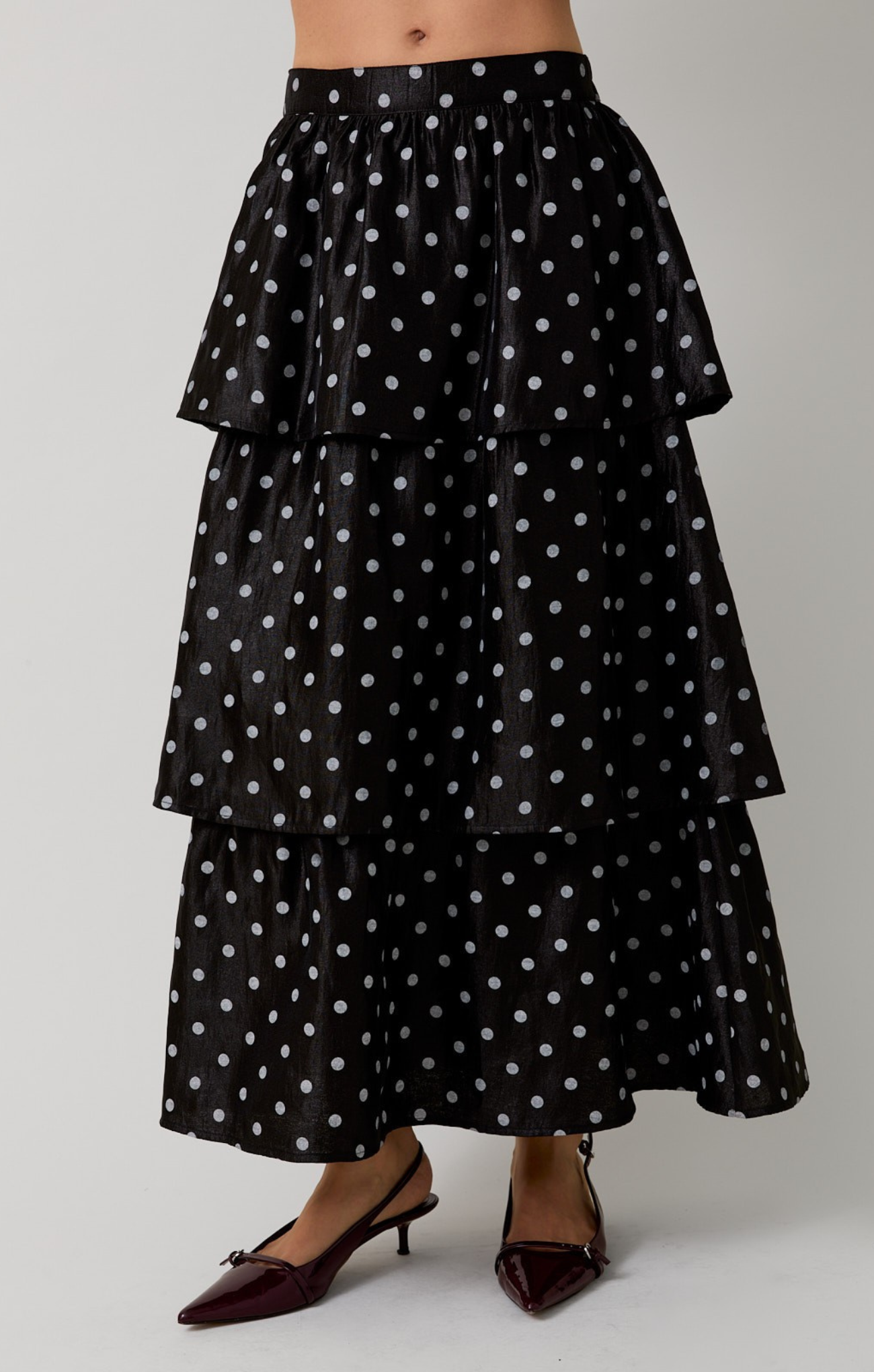 Black tiered polka dot skirt on a plain background