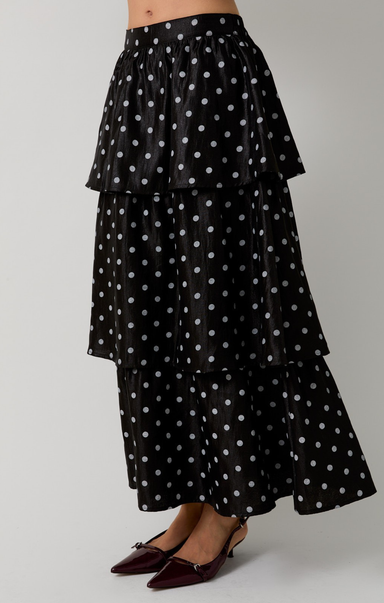 Black tiered skirt with white polka dots on a gray background