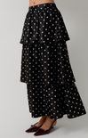 Black tiered skirt with white polka dots on a gray background