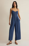Woman wearing a blue jumpsuit on a beige background