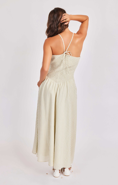 Woman wearing a light green dress with thin straps on a white background