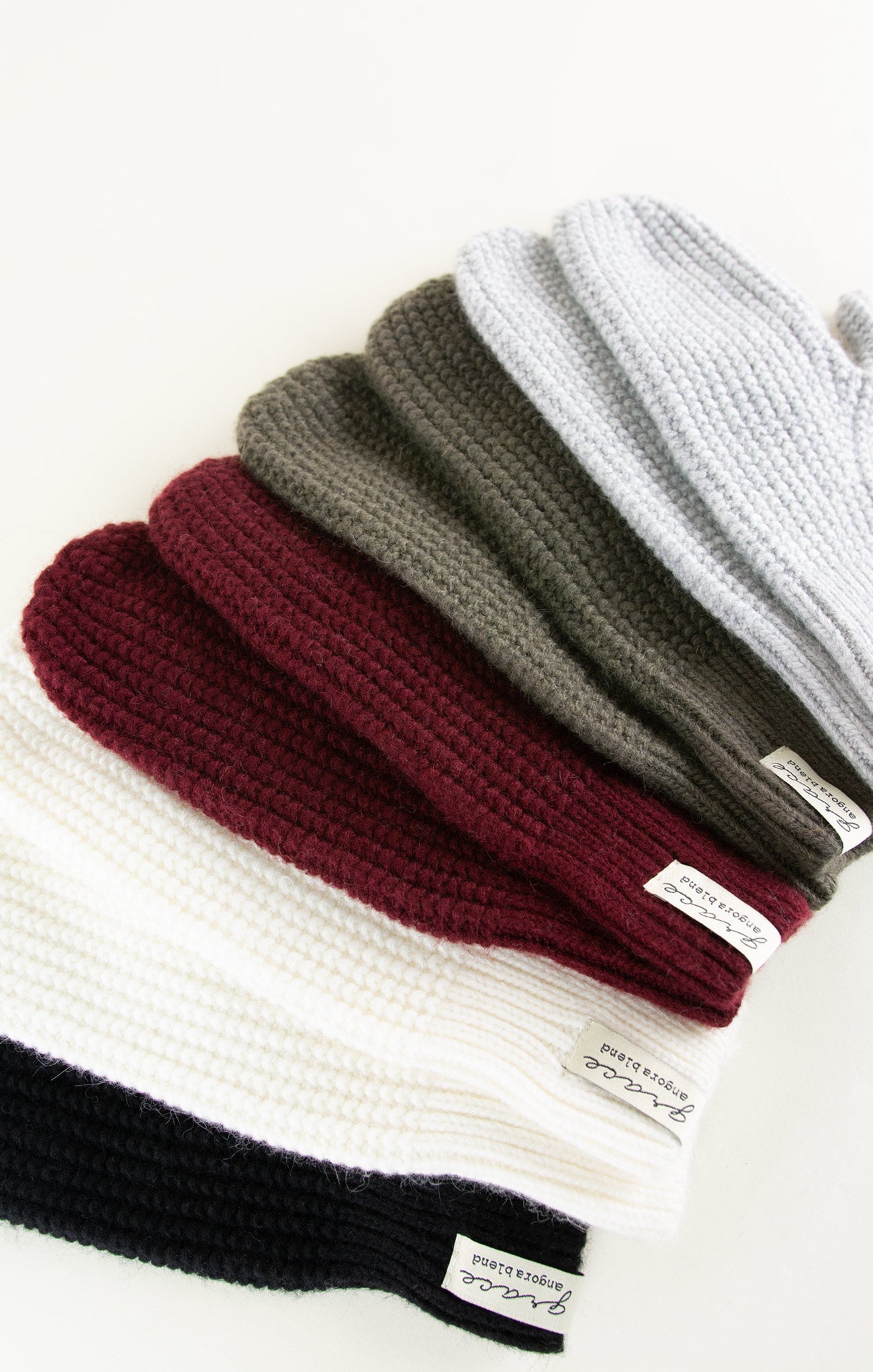 Set of knit beanies in various colors on a white background
