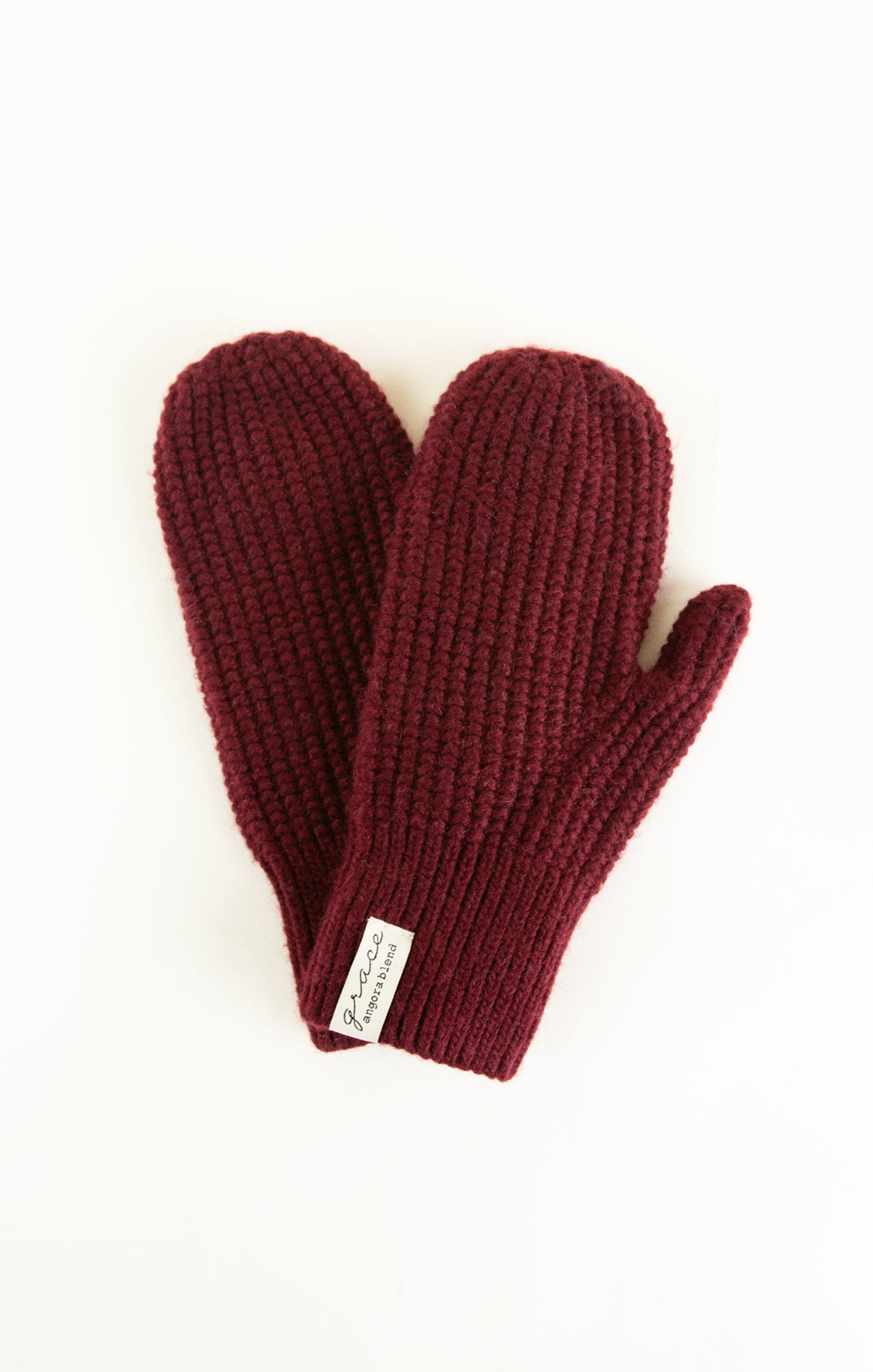 Pair of maroon knit mittens on a white background
