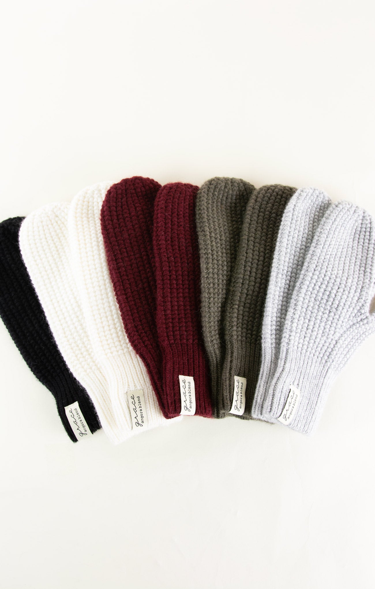 Set of six knit beanie hats in black, white, red, gray, and two other colors on a white background.