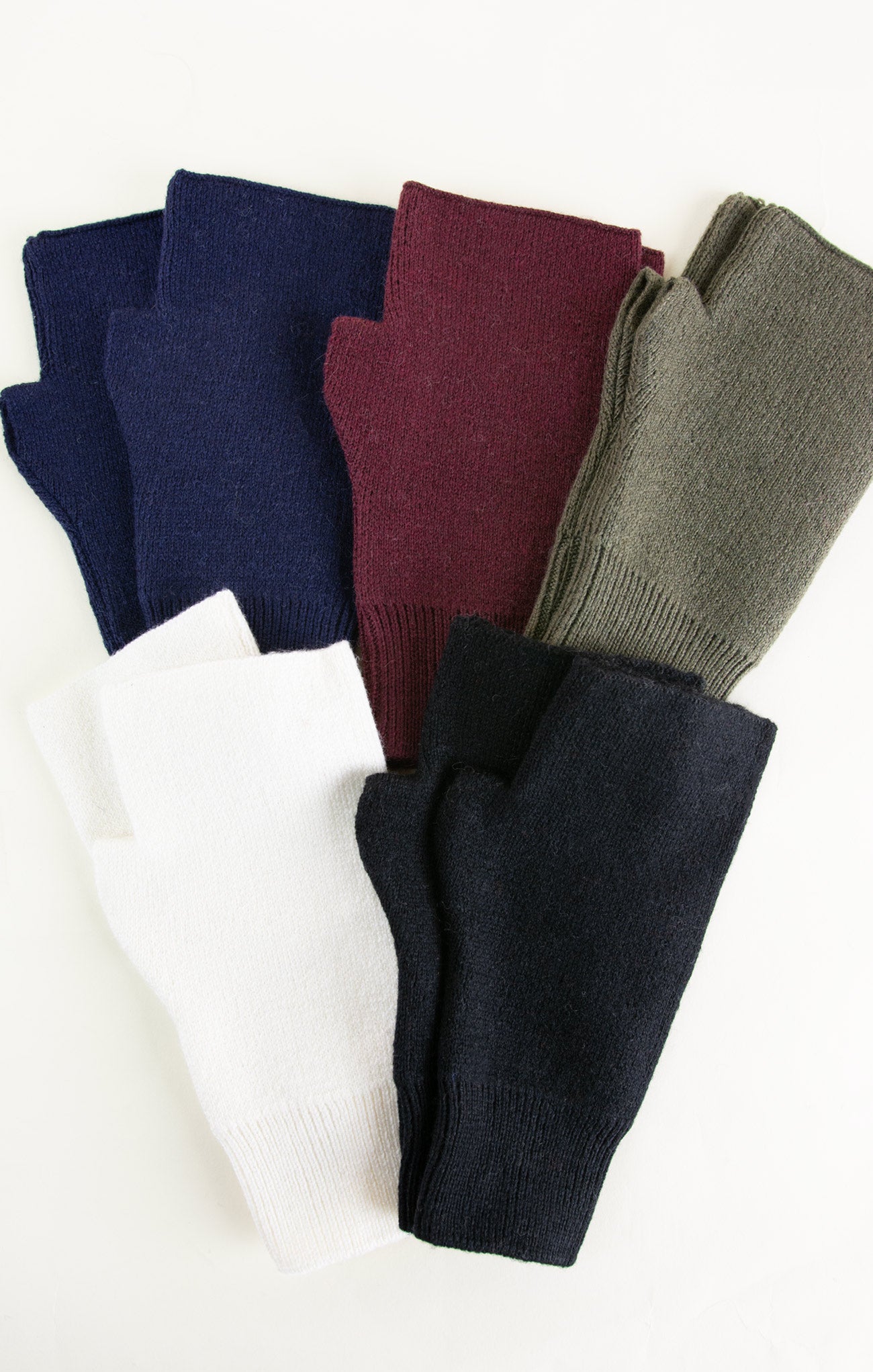Four pairs of fingerless gloves in navy, burgundy, gray, and black on a white background