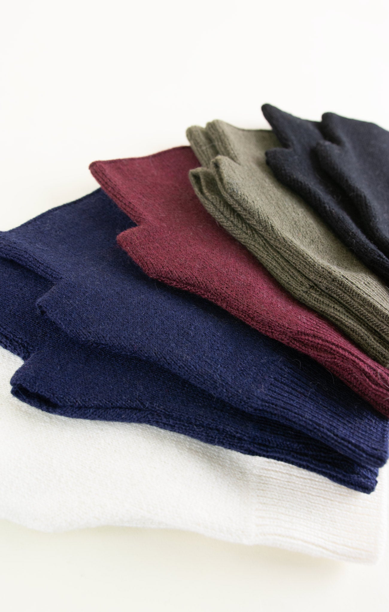 Stack of folded socks in various colors on a white background