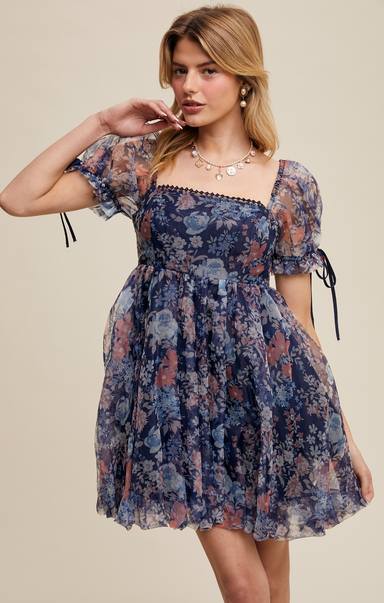 Woman wearing a floral dress against a beige background