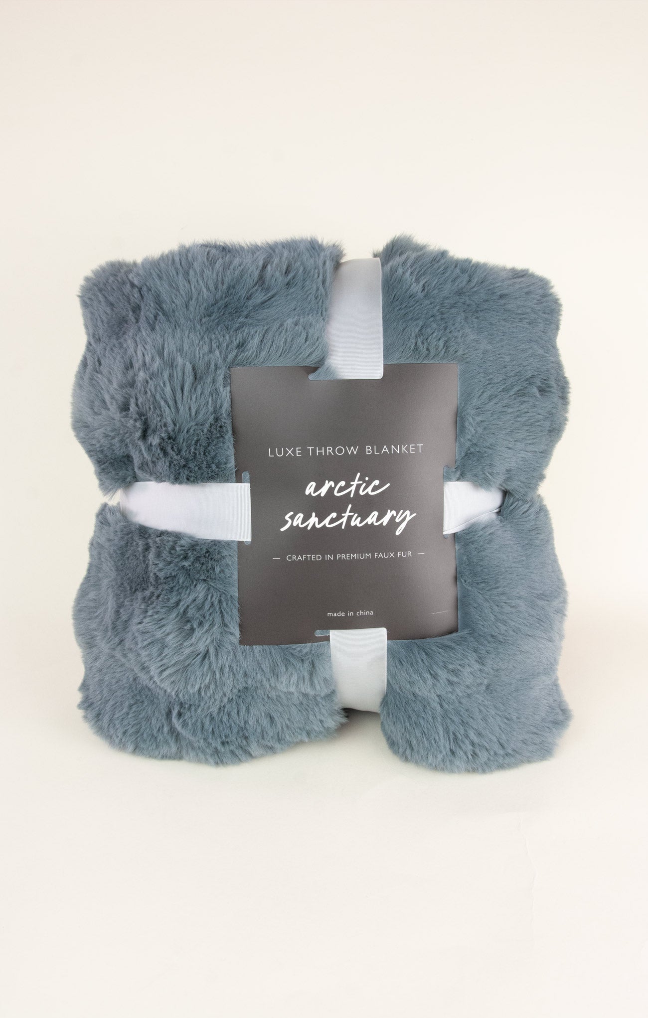 Blue throw blanket with a label on a white background