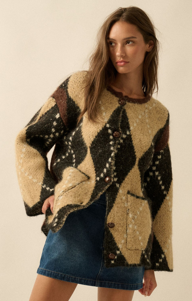 Woman wearing a patterned sweater and denim skirt against a neutral background