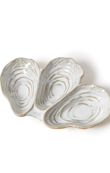 Three oyster-shaped ceramic dishes on a white background