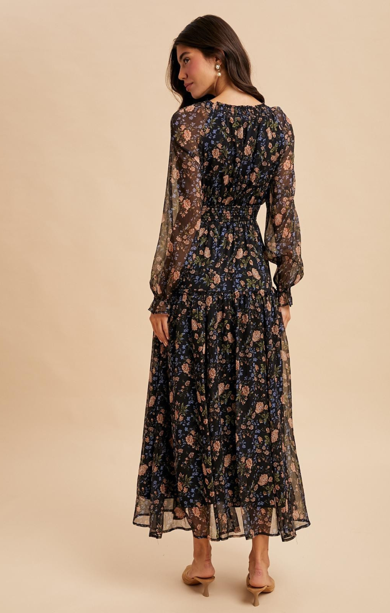 Woman wearing a floral dress against a beige background