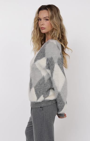 Woman wearing a gray and white patterned sweater on a white background