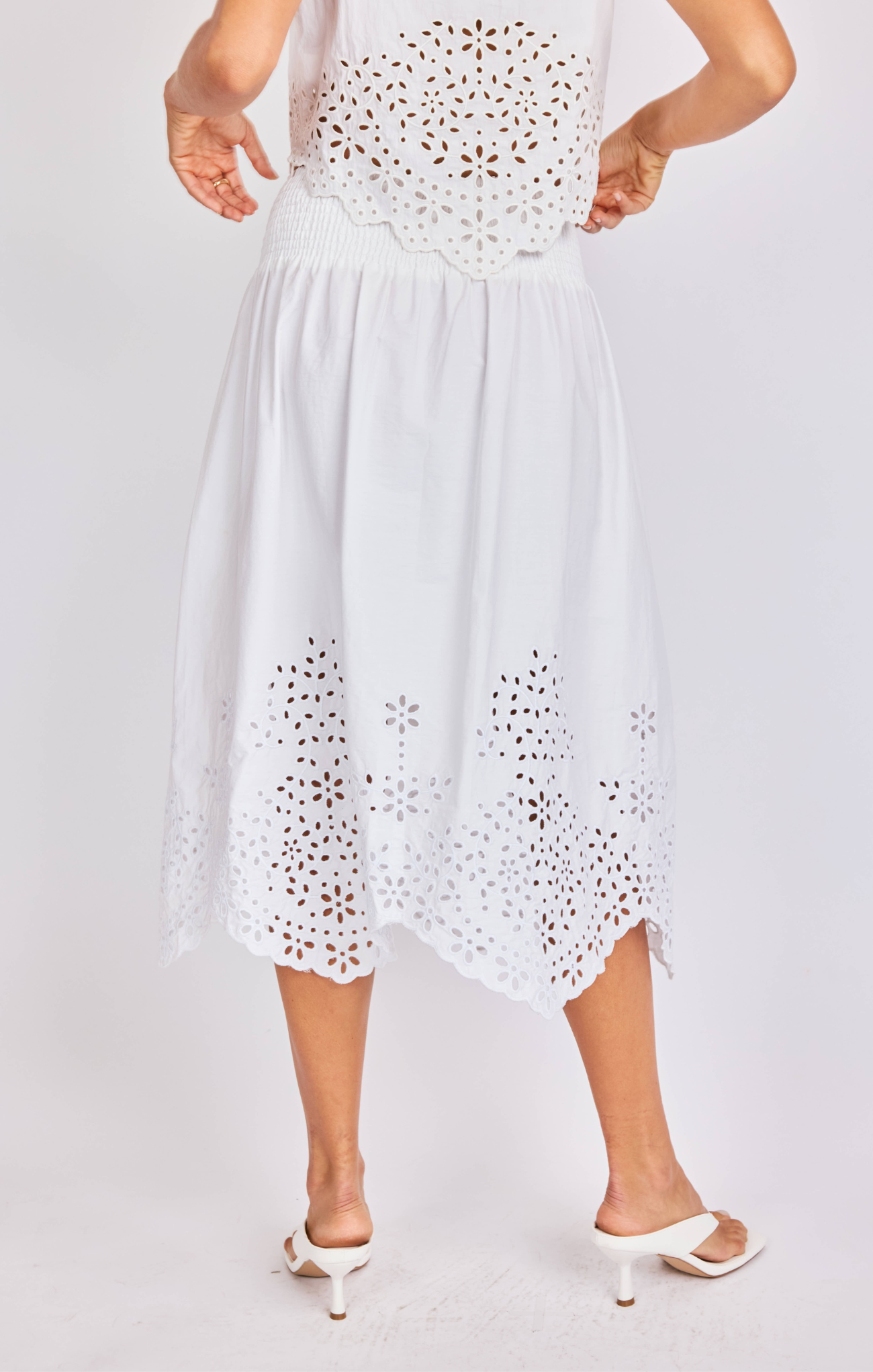 White dress with cut-out patterns on a plain background