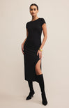 A woman wearing a black midi dress with a crew neck and short sleeves. The dress is fitted and reaches to the knee.