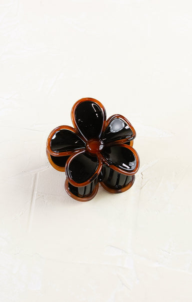 Flower-shaped hair clip with black and brown colors on a white background