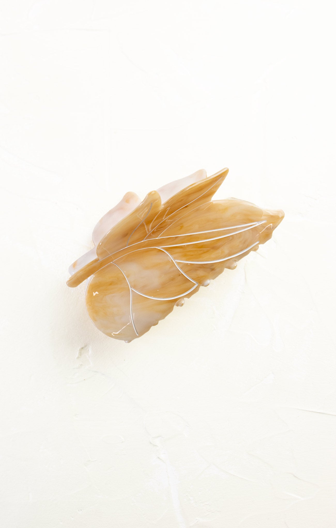 Decorative feather with gold and white accents on a white background