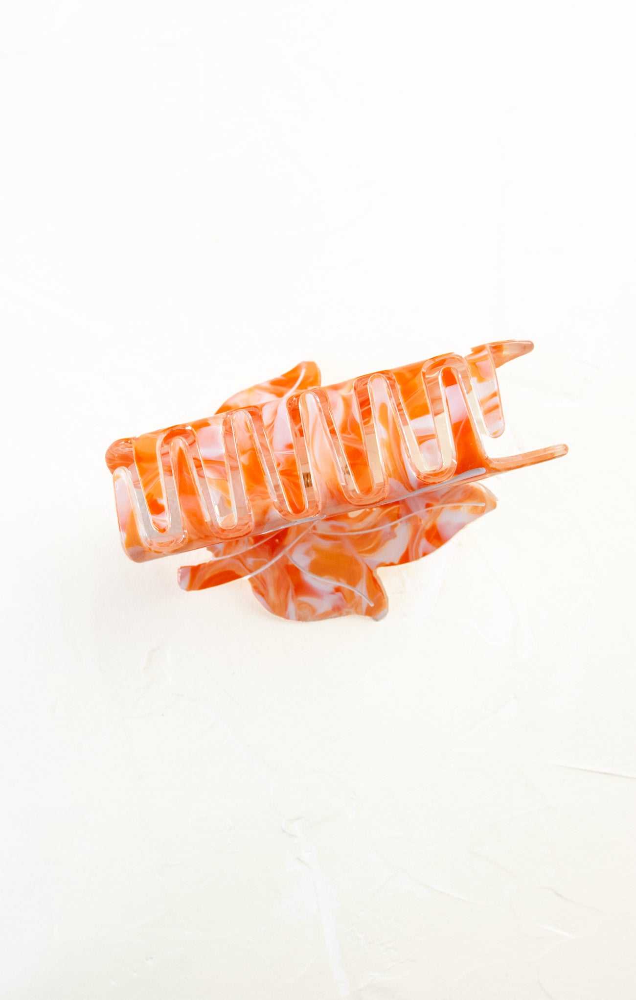Orange and white hair clip on a white background