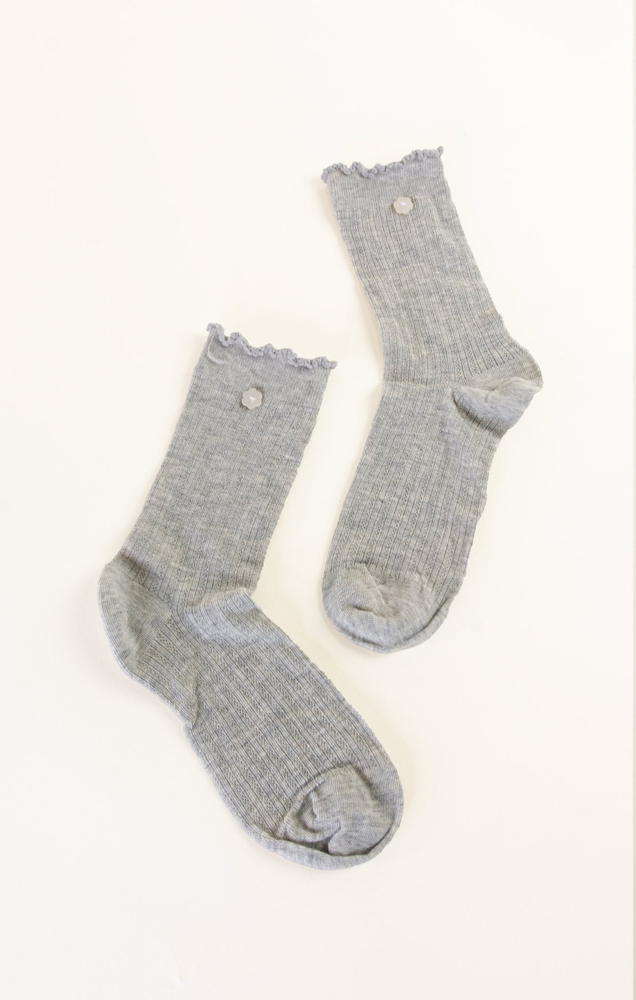Pair of gray socks with lace trim on a white background
