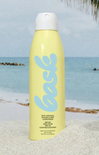 Yellow sunscreen spray bottle with blue logo on a beach