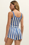 Woman wearing a blue and white striped romper on a beige background