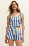 Woman wearing a blue and white striped romper on a beige background