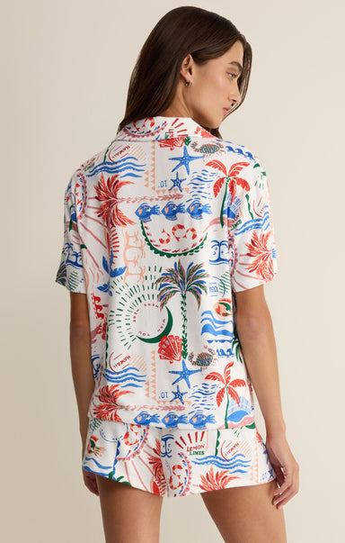 Woman wearing a colorful patterned shirt against a neutral background