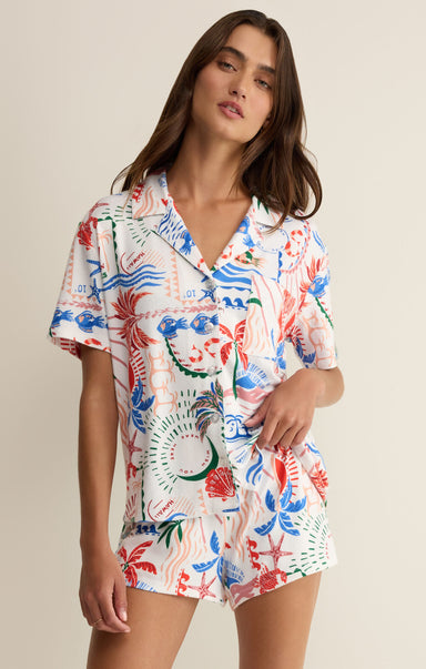 Woman wearing a colorful floral outfit on a beige background