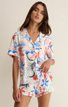 Woman wearing a colorful floral outfit on a beige background