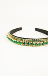 Black headband with green gemstones on a white background