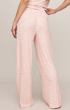Pink textured pants worn by a person on a plain background